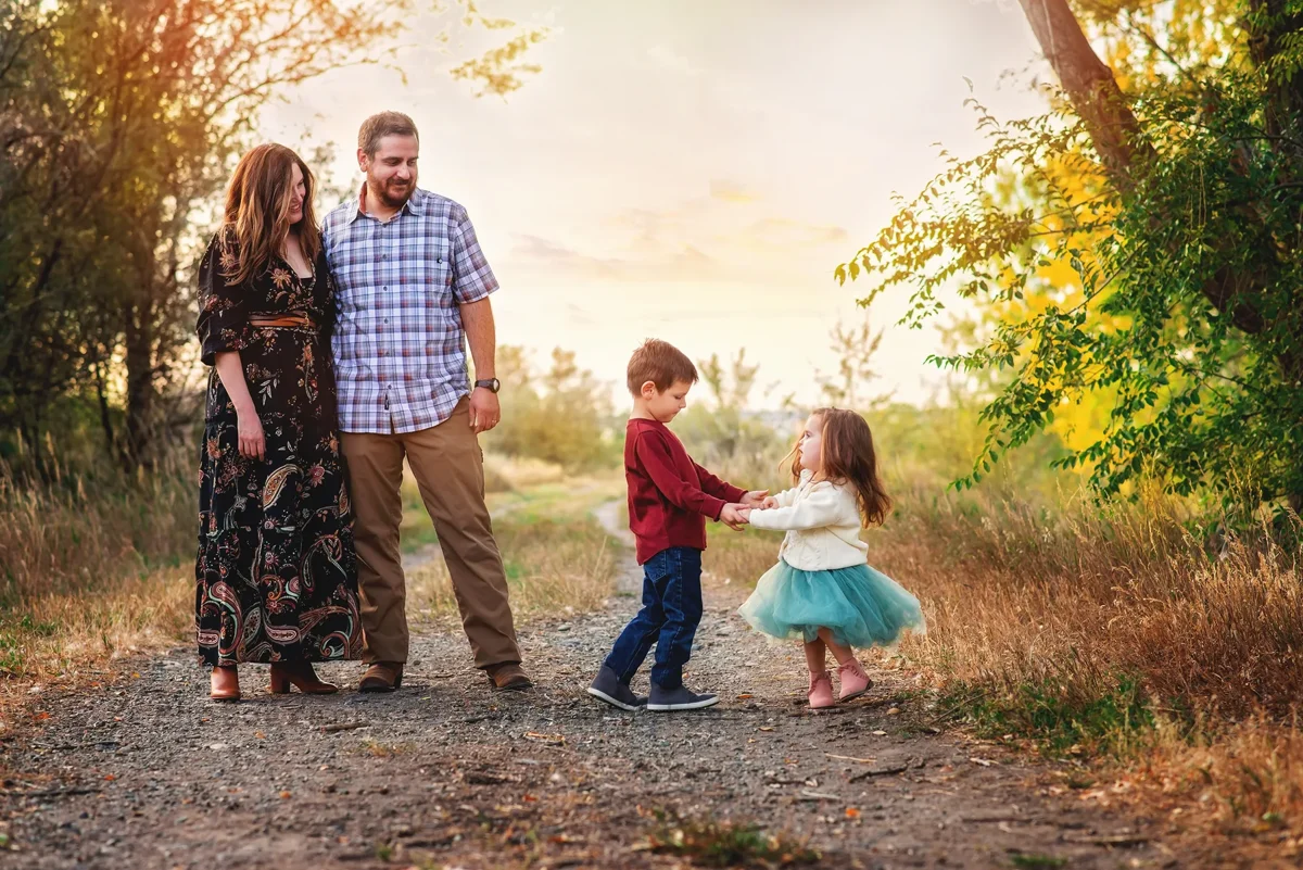 A family laughing together along a sunlit Montana path